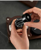 Black WDT distribution tool with needle head held over a portafilter