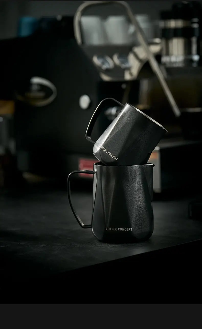 Black stainless milk pitcher tilted mid-pour for creating latte microfoam
