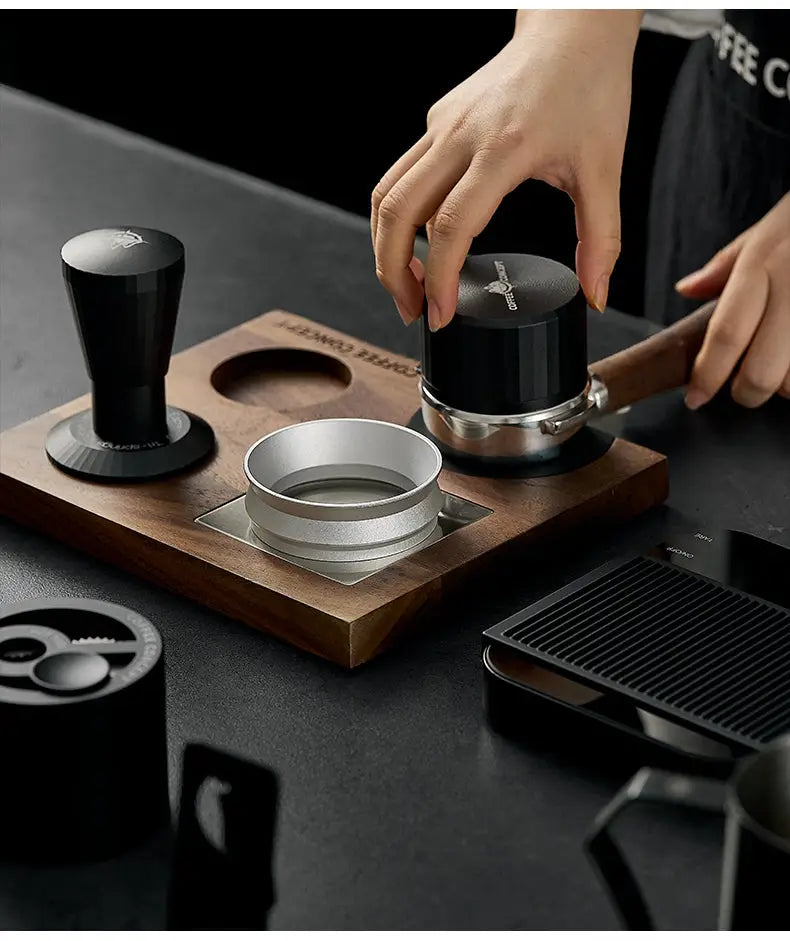 Hands place a magnetic anti-static espresso dosing ring onto the portafilter