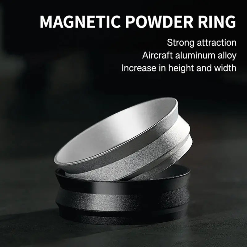 Magnetic powder ring in matte black and silver metal, stacked rings on a dark surface.