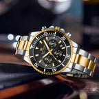 Gold and silver men's chronograph-style wristwatch with black dial and metal link band