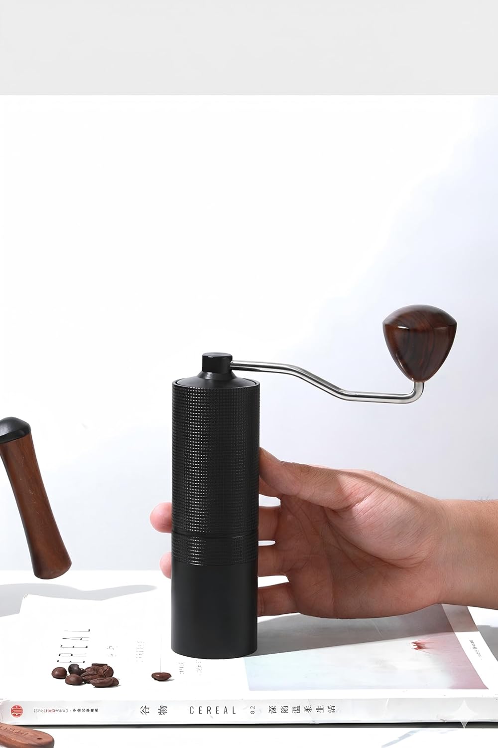 Handheld pour-over coffee grinder with wooden handle and black body
