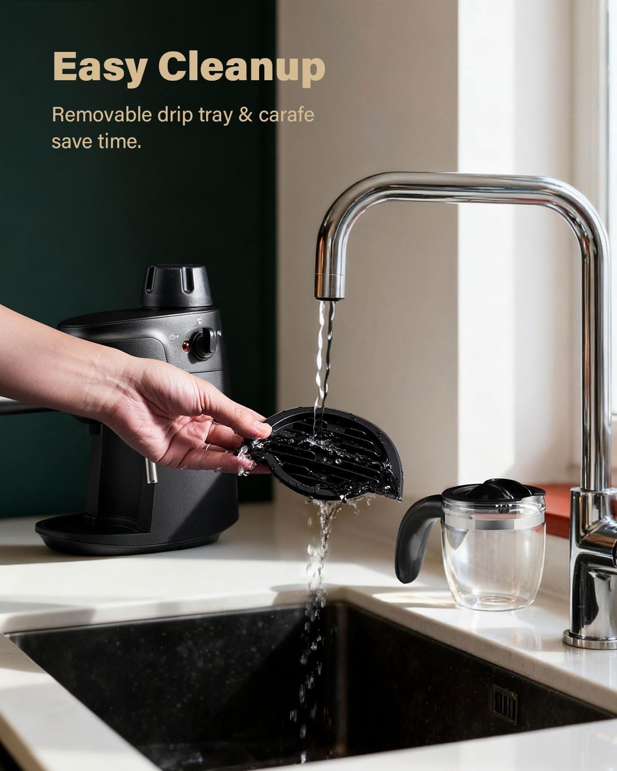 Black espresso machine with removable drip tray being rinsed at sink, stainless faucet
