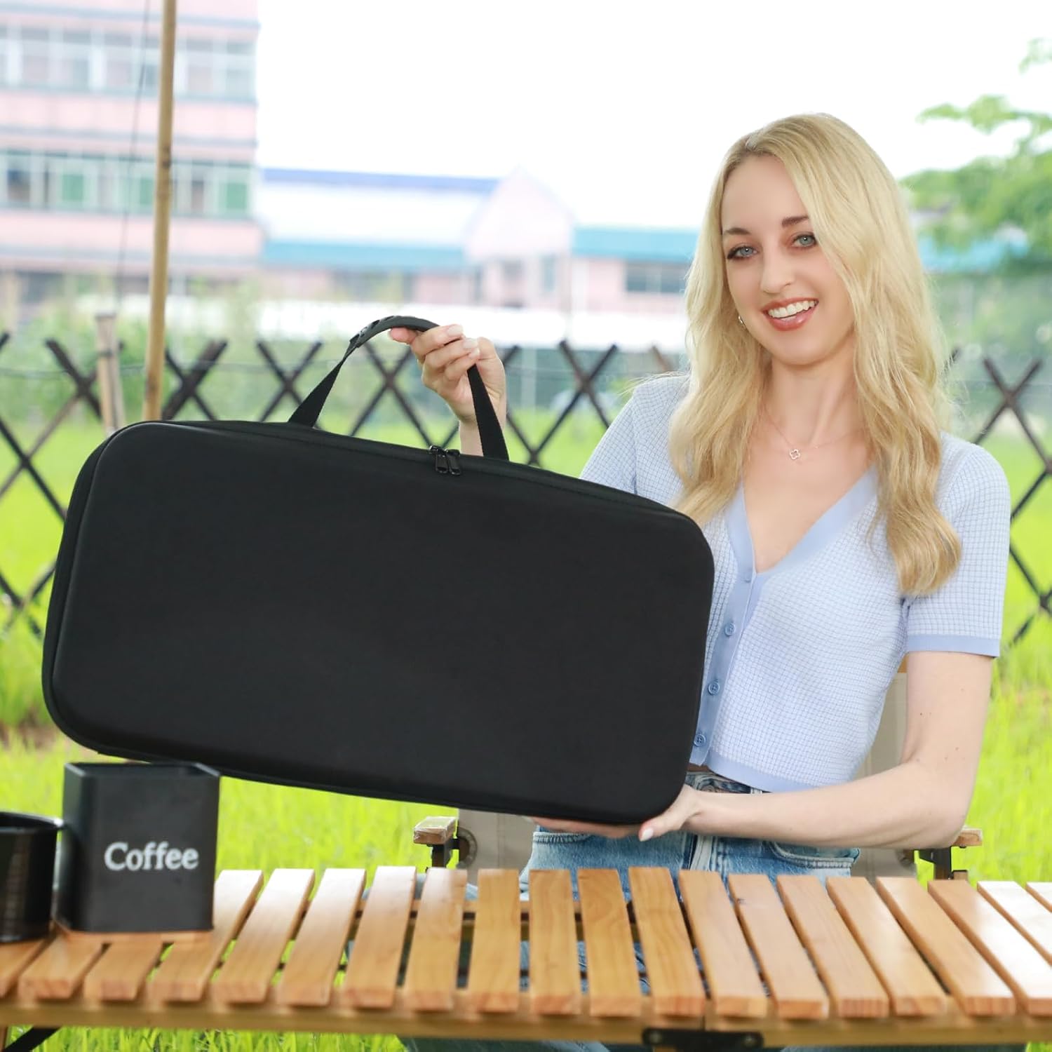 Person carrying black travel case holding portable pour-over coffee maker kit