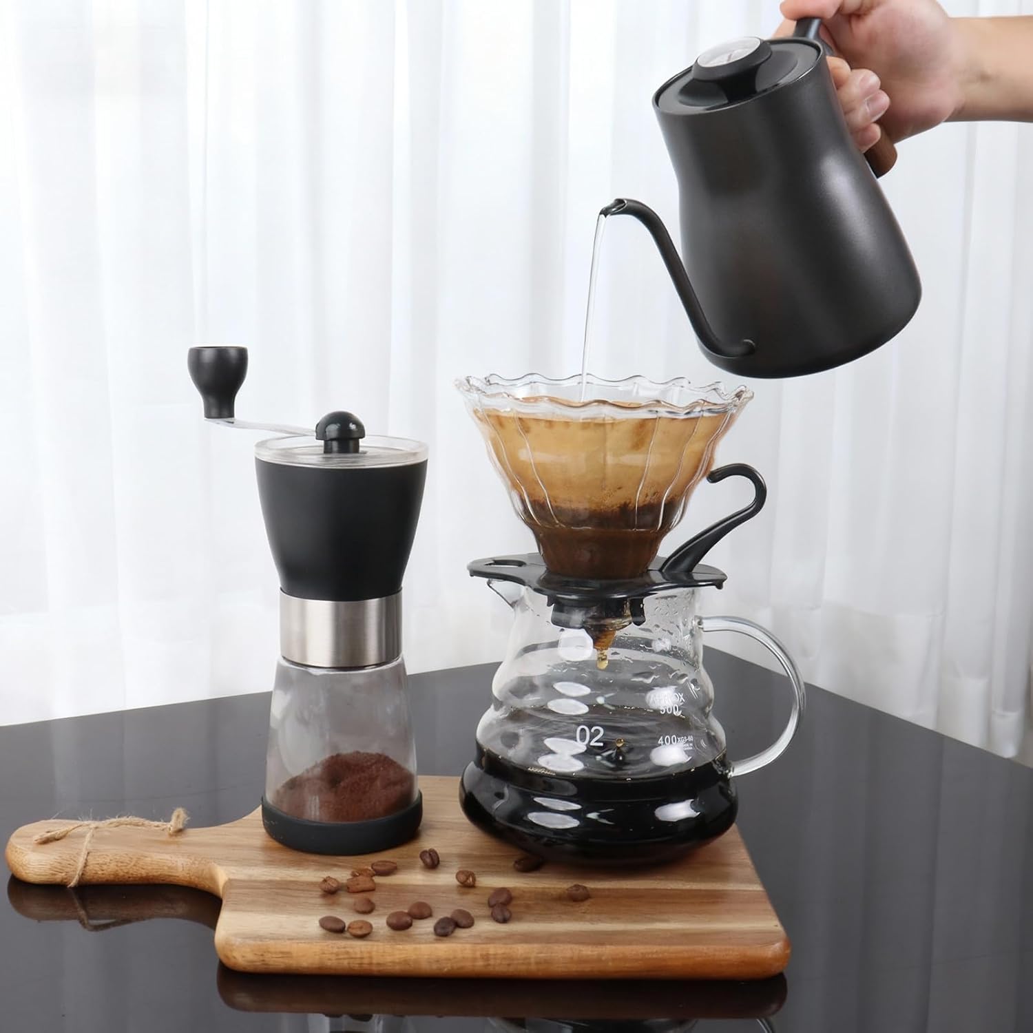 Coffee brewing station with gooseneck kettle, manual grinder, pour-over dripper and glass carafe