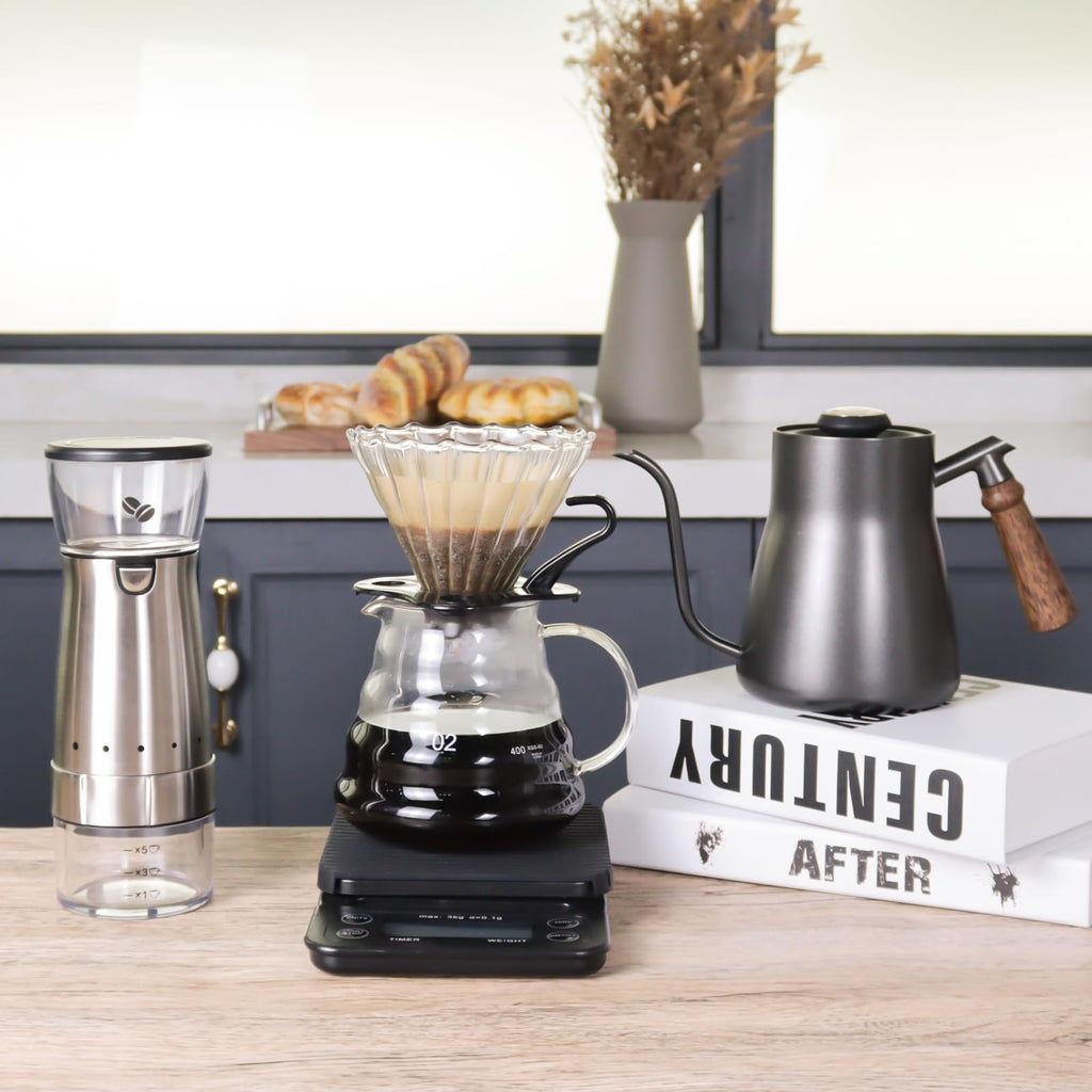 Stainless and black pour-over coffee kit with dripper, kettle, grinder, and glass carafe