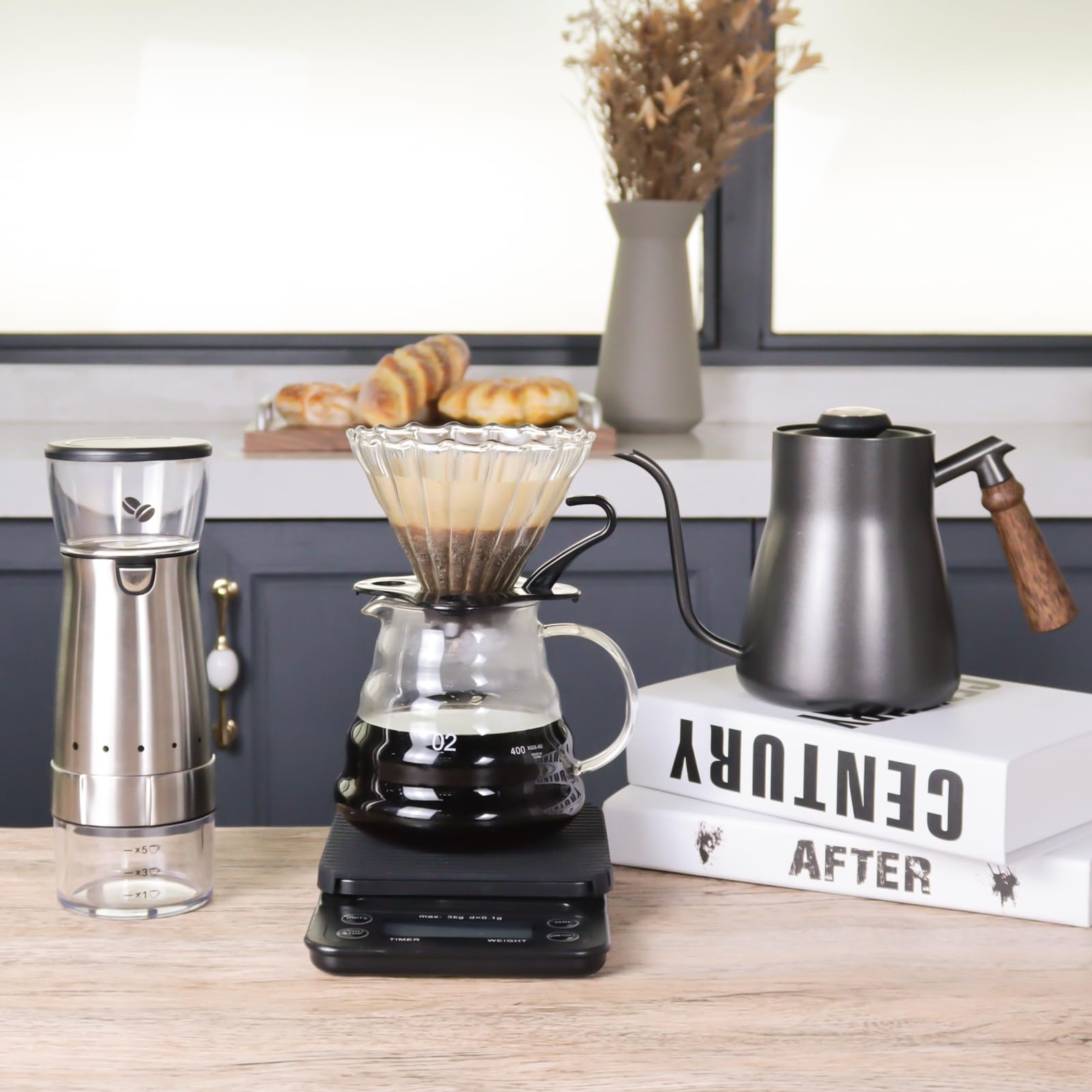 Stainless and black pour-over coffee kit with dripper, kettle, grinder, and glass carafe