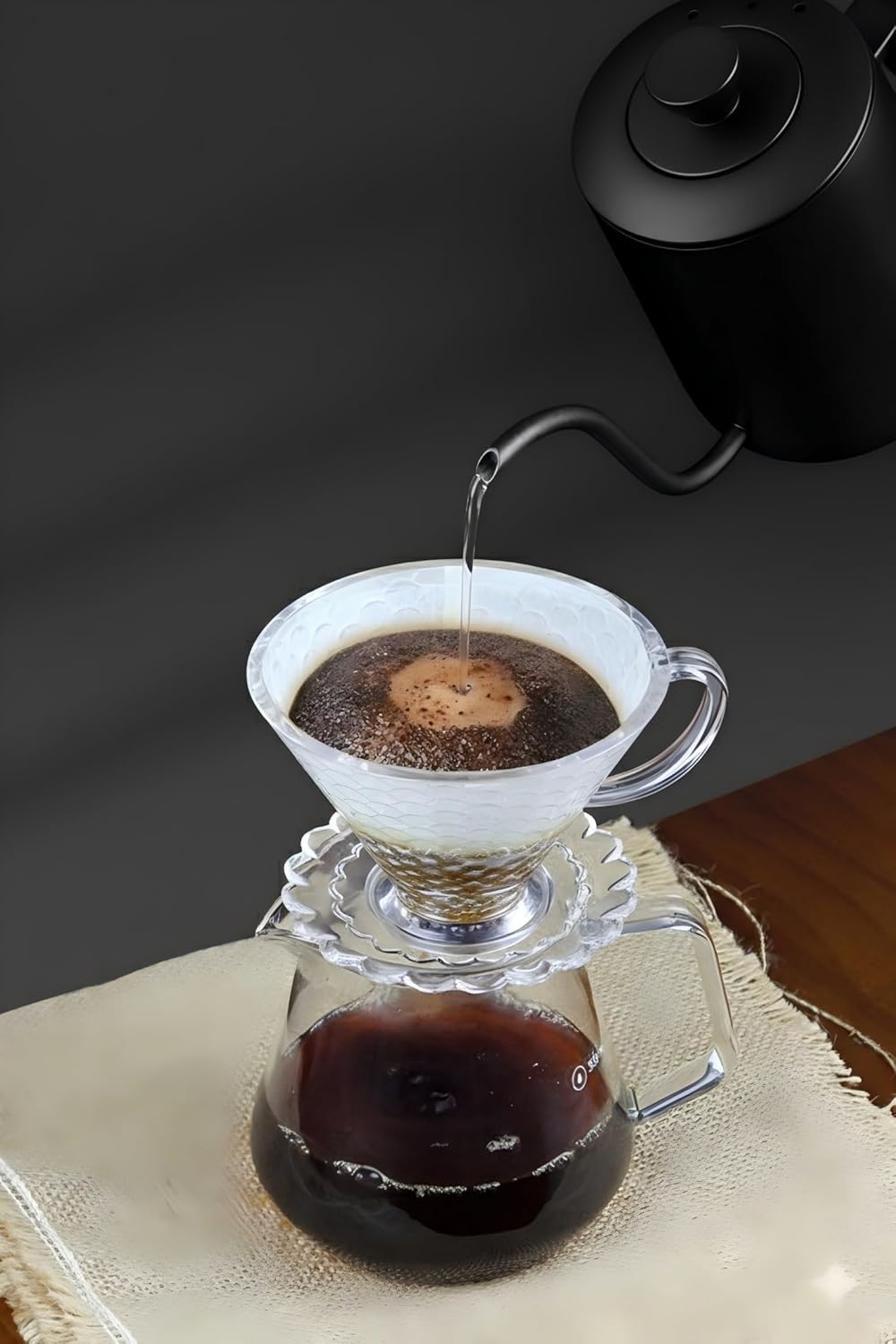 Glass pour-over carafe with brewed coffee in metal dripper and handle mug