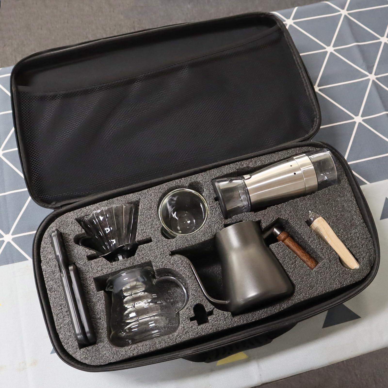 Coffee kit components in foam-lined zip travel bag: kettle, dripper, grinder, and filters