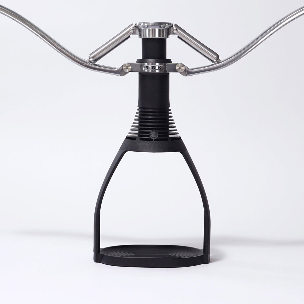 Black manual espresso maker with stainless arms and compact base stand