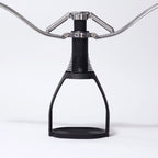 Black manual espresso maker with stainless arms and compact base stand