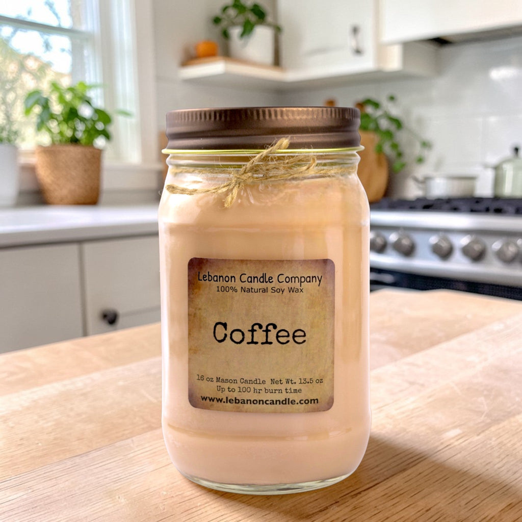 Coffee-scented candle in clear glass jar on a wooden tabletop