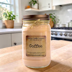 Coffee-scented candle in clear glass jar on a wooden tabletop