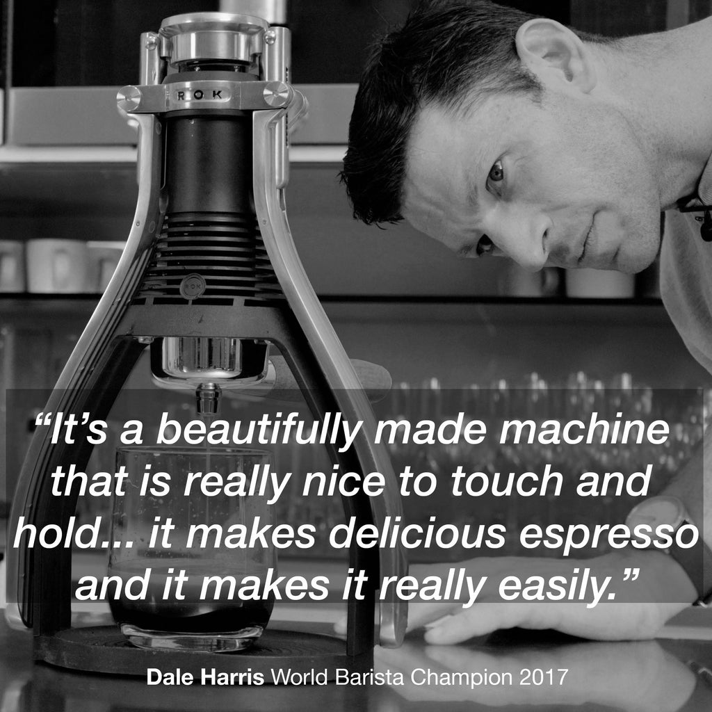 Black manual espresso maker with stainless chamber and filter head, on countertop