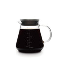 Glass coffee carafe with handle and spout, dark brew inside, visible volume scale.