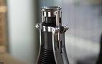 Stainless and black manual espresso maker close-up of top chamber and press lever