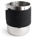 Stainless milk frothing pitcher with black silicone grip and interior measuring marks