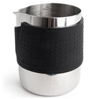 Stainless milk frothing pitcher with black silicone grip and interior measuring marks