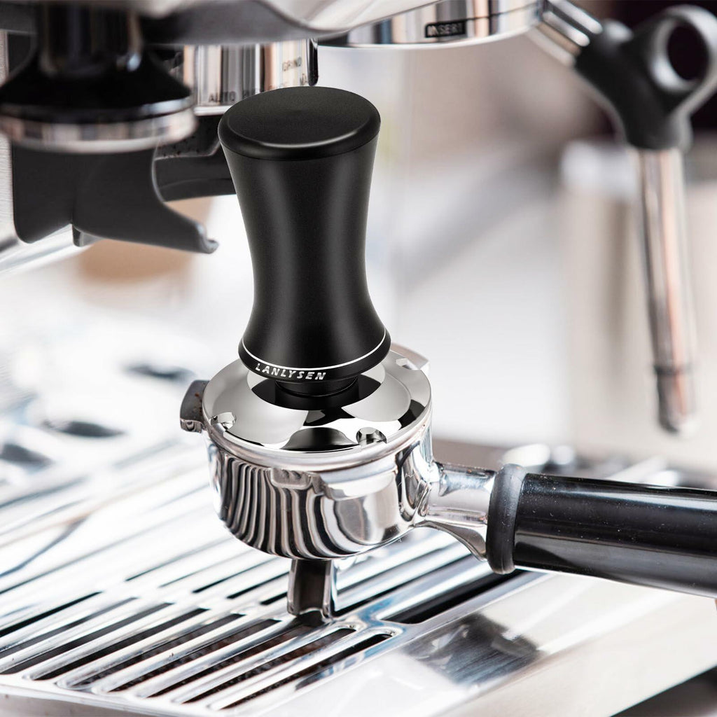 Spring-loaded espresso tamper mounted on an espresso machine portafilter
